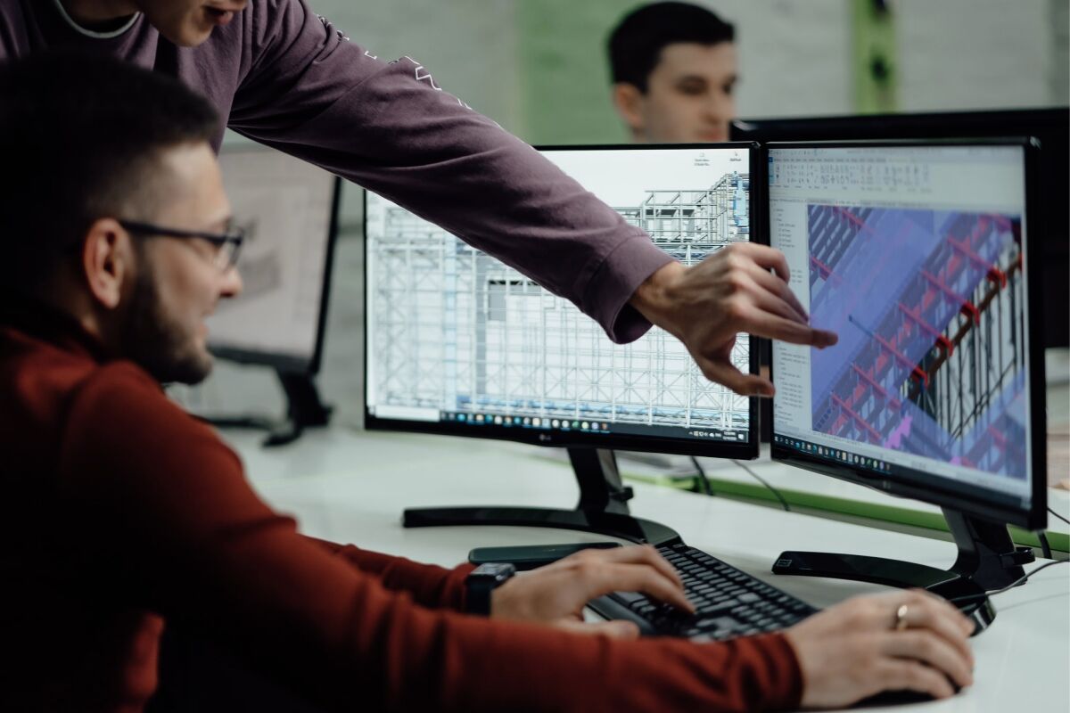 Colleagues collaborating while examining building designs on a computer